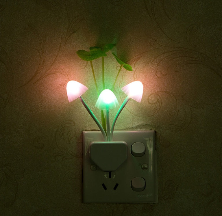 Flower-shaped night light attached to a wall socket with a dark background