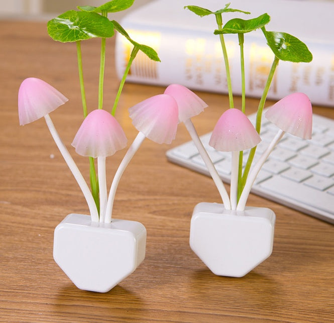 Two pink mushroom-shaped desk lamps on a wooden surface with a keyboard in the background.